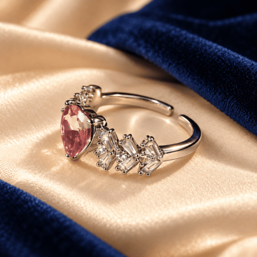 Side view of a pink heart stone ring showing clear accents and a silver-tone open-ended band