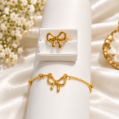 Gold-tone bow bracelet and matching bow ring on a display stand