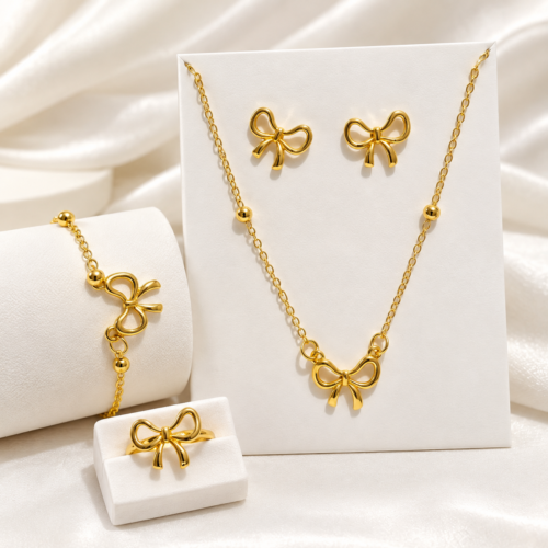 Complete gold-tone bow jewellery set with necklace, pair of earrings, bracelet and ring