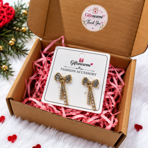 Gold-tone bow earrings with clear stones in gift-box packaging