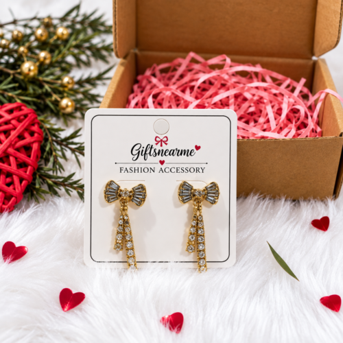Golden Bow Sparkle Earrings on a gift card beside an open gift box