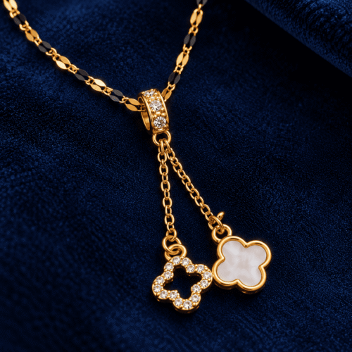 Close-up of twin white and clear-stone clover charms on Golden Clover Necklace