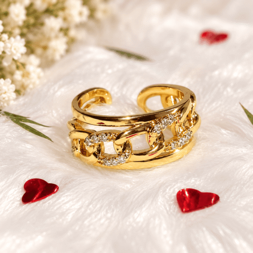 Gold-tone chain-link ring displayed on white fur with red heart decorations