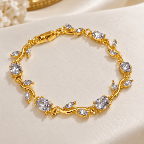 Complete gold-tone vine bracelet with clear oval stones and leaf details on ivory satin