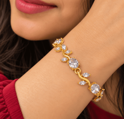 Woman wearing a gold-tone vine bracelet with clear oval and leaf-shaped stones