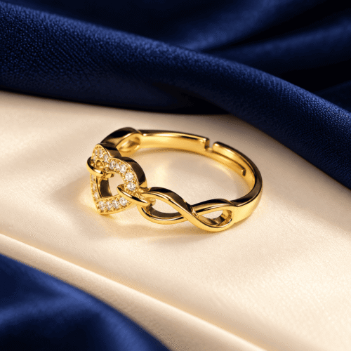 Side detail of a gold-tone ring with an open heart, clear stones and flowing infinity links