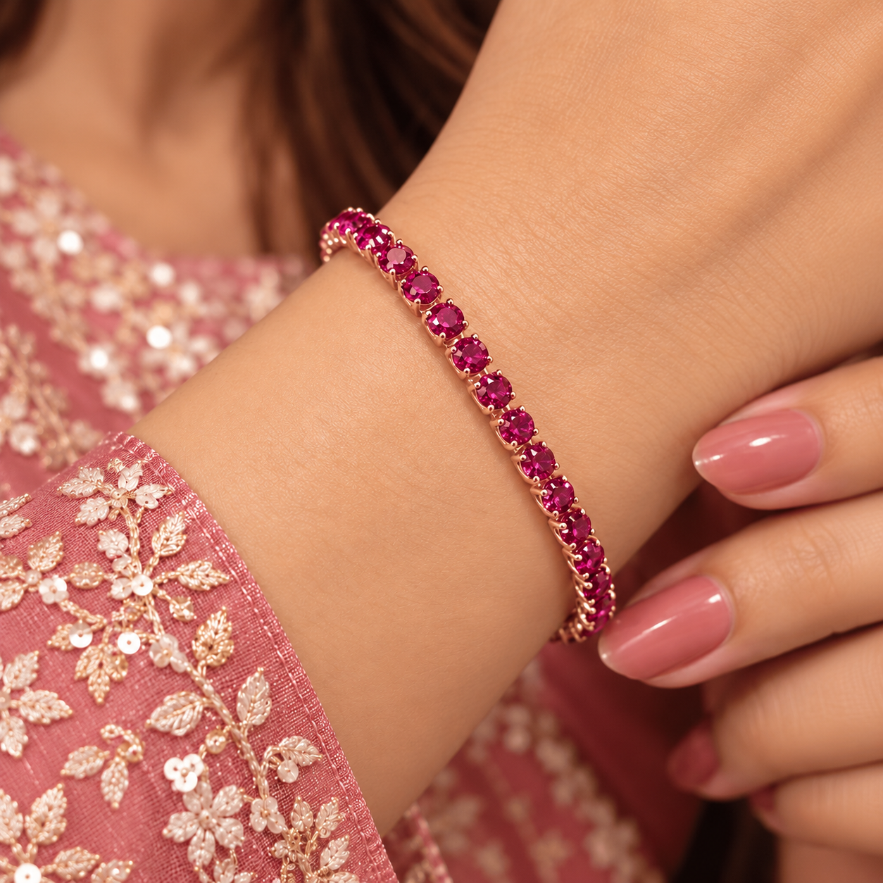 Magenta Glow Bracelet Worn on Wrist Woman wearing a rose gold-tone bracelet with a single row of round magenta-pink stones