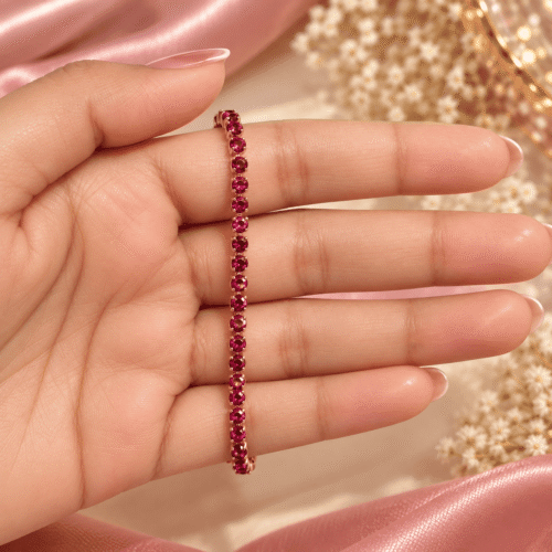 Close-up of a rose gold-tone single-row bracelet with round magenta-pink stones held in a hand