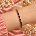 Rose gold-tone bracelet with round black stones worn on a wrist