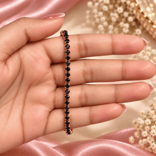 Rose gold-tone bracelet with a single row of round black stones held in a hand
