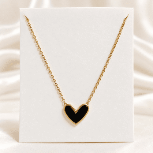 Black heart necklace with gold-tone border and chain on a white display card