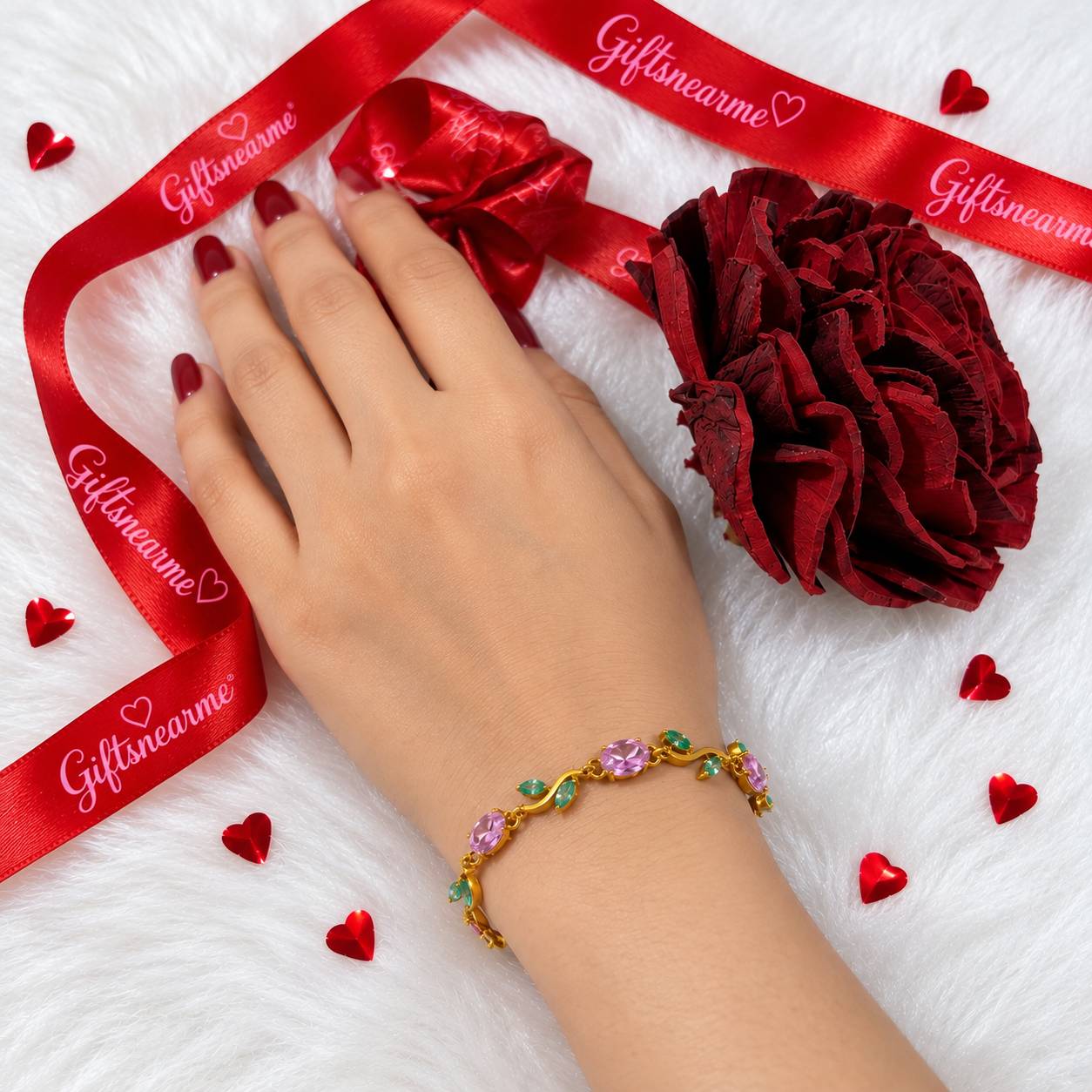 Pink Blossom Bracelet Worn on Wrist Woman wearing a gold-tone bracelet with pink oval stones and green leaf details