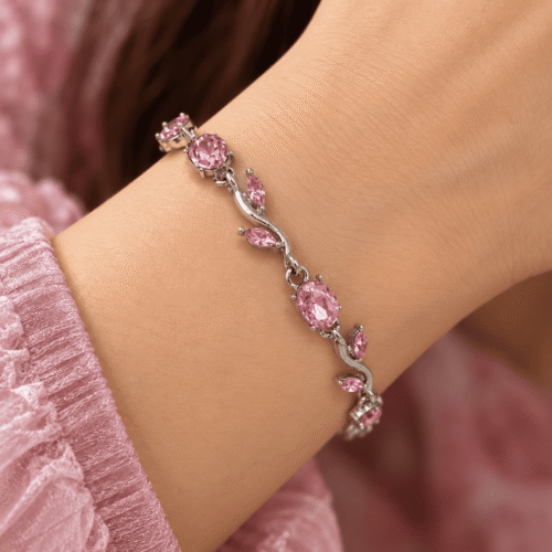 Pink vine bracelet with oval stones and silver-tone leaf details worn on a woman's wrist