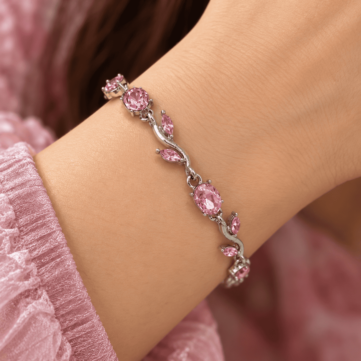 Pink Vine Bracelet Worn on Wrist Pink vine bracelet with oval stones and silver-tone leaf details worn on a woman's wrist