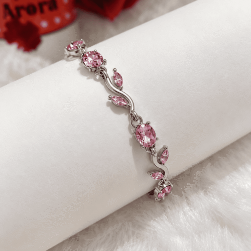 Pink vine bracelet with silver-tone links displayed on an ivory bracelet stand