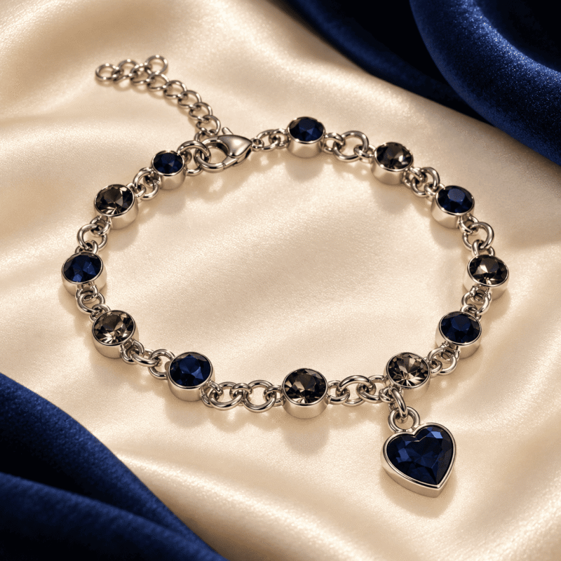 Sapphire Heart Bracelet with round navy-blue and smoky-grey stones and an extension chain on ivory satin