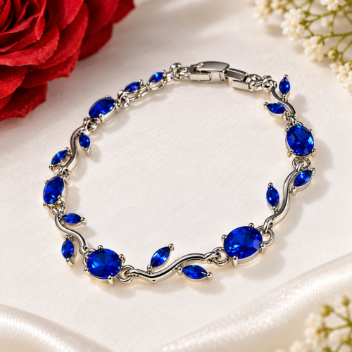 Silver-tone bracelet with sapphire-blue oval stones and leaf-shaped details