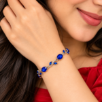 Woman wearing a silver-tone vine bracelet with blue oval stones and leaf details