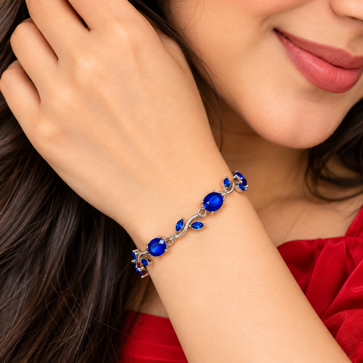 Sapphire Vine Bracelet Worn on Wrist Woman wearing a silver-tone vine bracelet with blue oval stones and leaf details