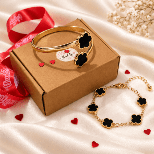 Black clover cuff bangle and chain bracelet with a gold-tone finish displayed beside a gift box